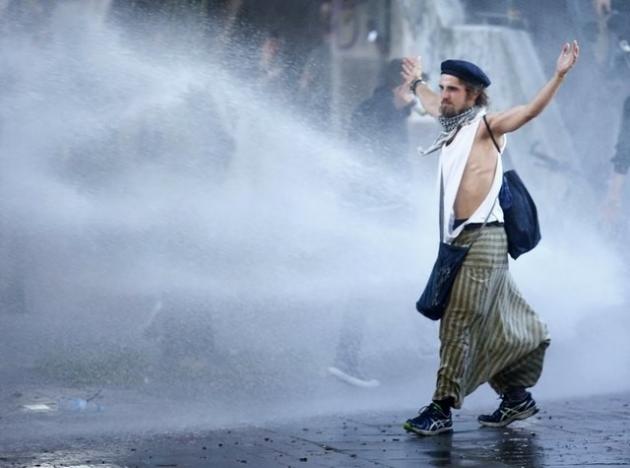 A protester walks as German riot police use water cannons during the demonstration at the G20 summit in Hamburg, Germany, July 6, 2017. REUTERS/Hannibal Hanschke