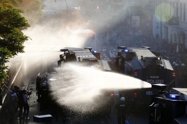 German riot police use water cannons against protesters during demonstrations. REUTERS/Fabrizio Bensch