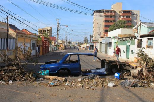 A wrecked car and others debris, used as a barricade, are seen on an empty street during a strike called to protest against Venezuelan President Nicolas Maduro
