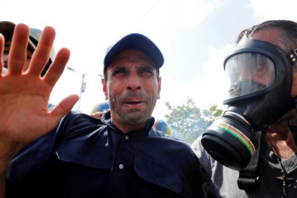 Venezuela opposition leader and Governor of Miranda state Henrique Capriles (C) reacts as he is affected by tear gas while rallying against Venezuela