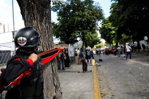 A demonstrator uses a slingshot at a rally during a strike called to protest against Venezuelan President Nicolas Maduro