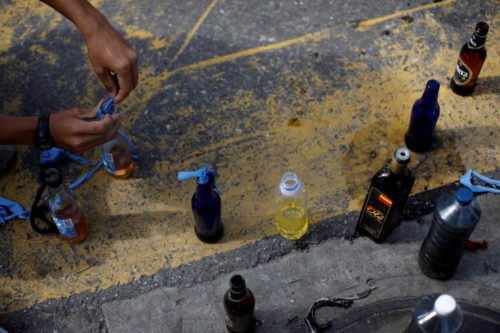 A demonstrator prepares petrol bombs during a strike called to protest against Venezuelan President Nicolas Maduro