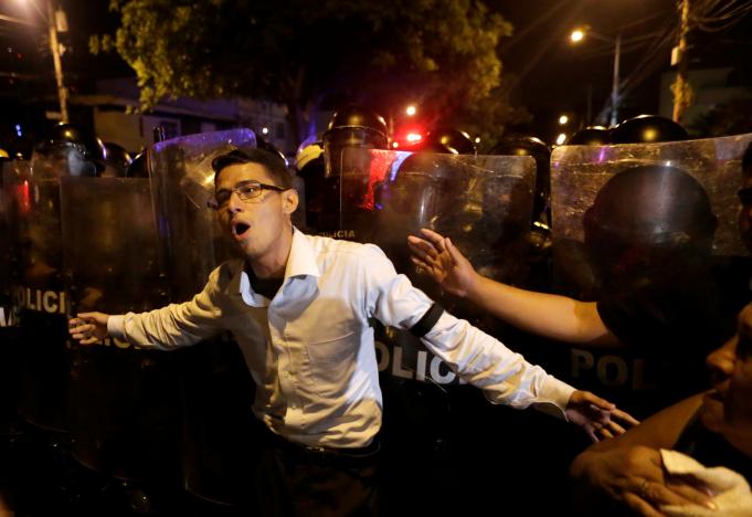 Supporters of Ecuadorean presidential candidate Guillermo Lasso demonstrate as riot police stand guard outside the national electoral council headquarters in Guayaquil during a national election day, Ecuador, April 2, 2017.   REUTERS/Henry Romero