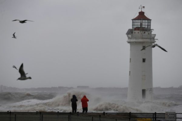 AFP / Paul ELLIS Walkers take photographs of stormy seas by the lighthouse in New Brighton, northwest England, as Storm Eleanor swept over the country