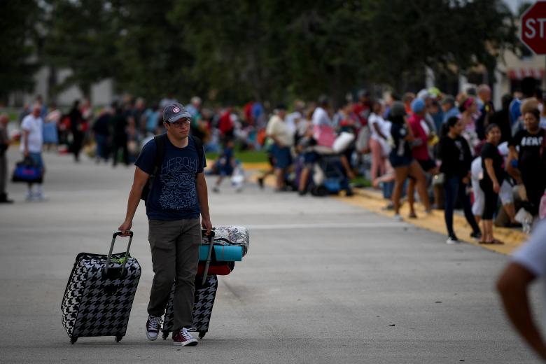 A man searches for the end of the line to shelter inside the Germain Arena in Estero. REUTERS/Bryan Woolston