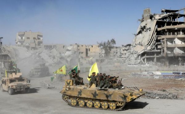 Syrian Democratic Forces (SDF) fighters ride atop of military vehicles as they celebrate victory in Raqqa. REUTERS/Erik De Castro