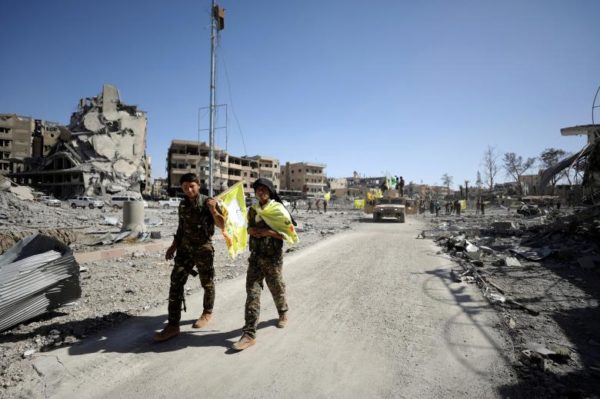 Fighters of Syrian Democratic Forces walk along a street in Raqqa. REUTERS/Rodi Said