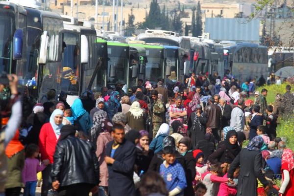 People that were evacuated from the two villages of Kefraya and al-Foua walk near buses, after a stall in an agreement between rebels and Syria